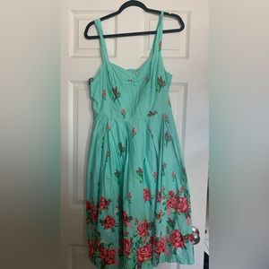 This is a Lindy Bop dress, it’s a cyan type of dress with pink roses.